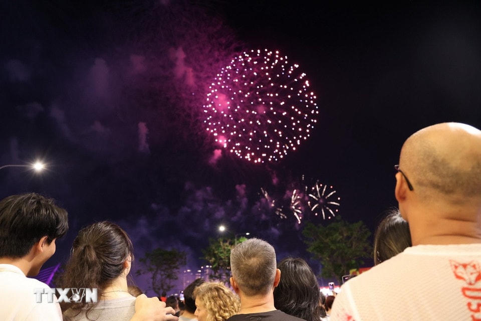 Người dân, du khách xem pháo hoa tại khu vực bến Bạch Đằng (Quận 1). (Ảnh: Thu Hương/TTXVN)