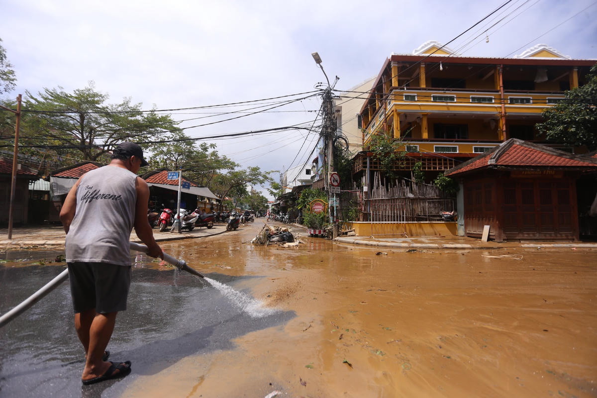 Người dân TP Hội An xịt nước rửa trôi lớp bùn non.