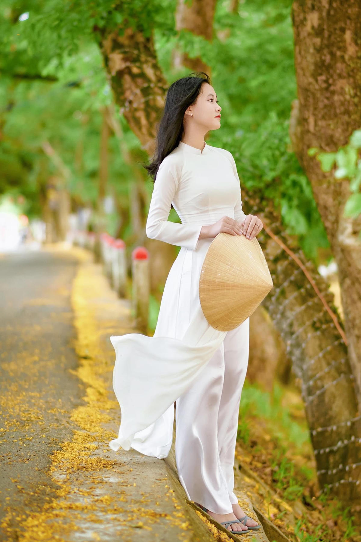 Một bạn gái trẻ tạo dáng bên hoa sưa.