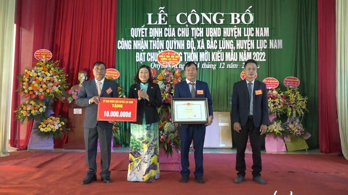 Bà Giáp Thị Hải - Trưởng ban Dân vận, Chủ tịch Ủy ban MTTQ huyện Lục Nam trao chứng nhận và tiền thưởng cho cán bộ và nhân dân thôn Quỳnh Độ, xã Bắc Lũng đạt chuẩn nông thôn mới kiểu mẫu.