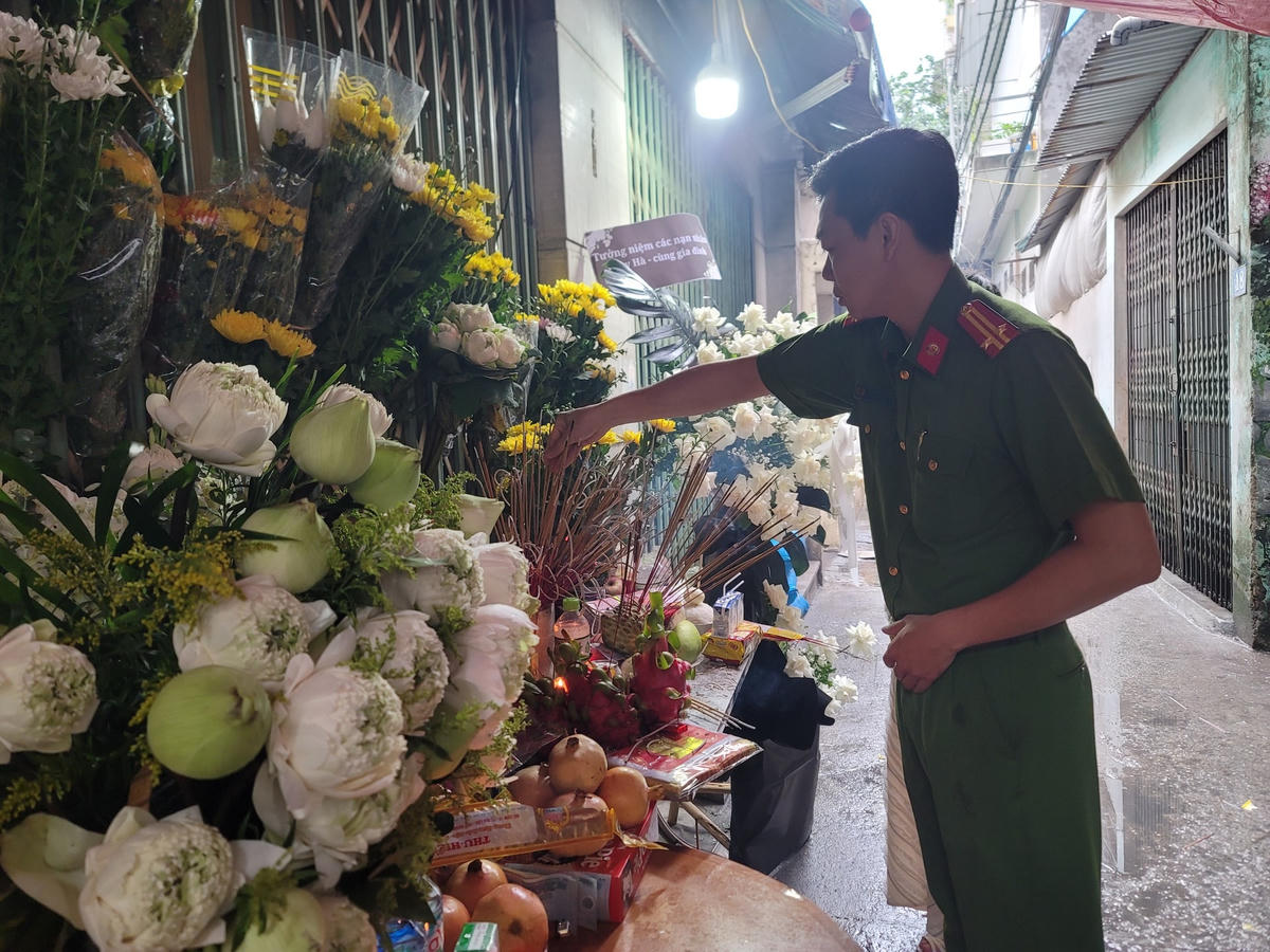 Người dân đội mưa đến chung cư mini bị cháy đặt hoa tưởng niệm các nạn nhân 