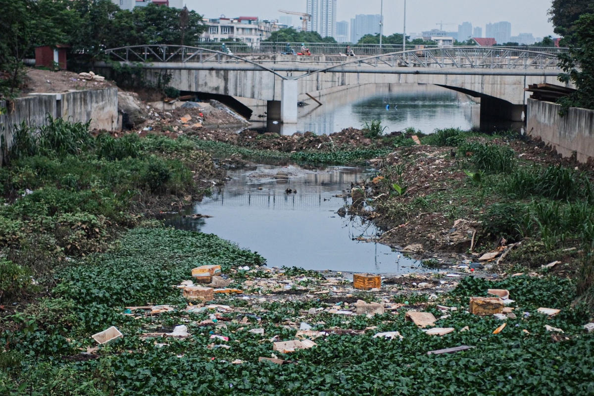 Tại khu vực cầu Ỷ La (quận Hà Đông), thùng sốp, ác thải được chất đầy hai bên bờ và giữa dòng chảy, khiến cả con mương rất rộng cũng trở nên chật hẹp.