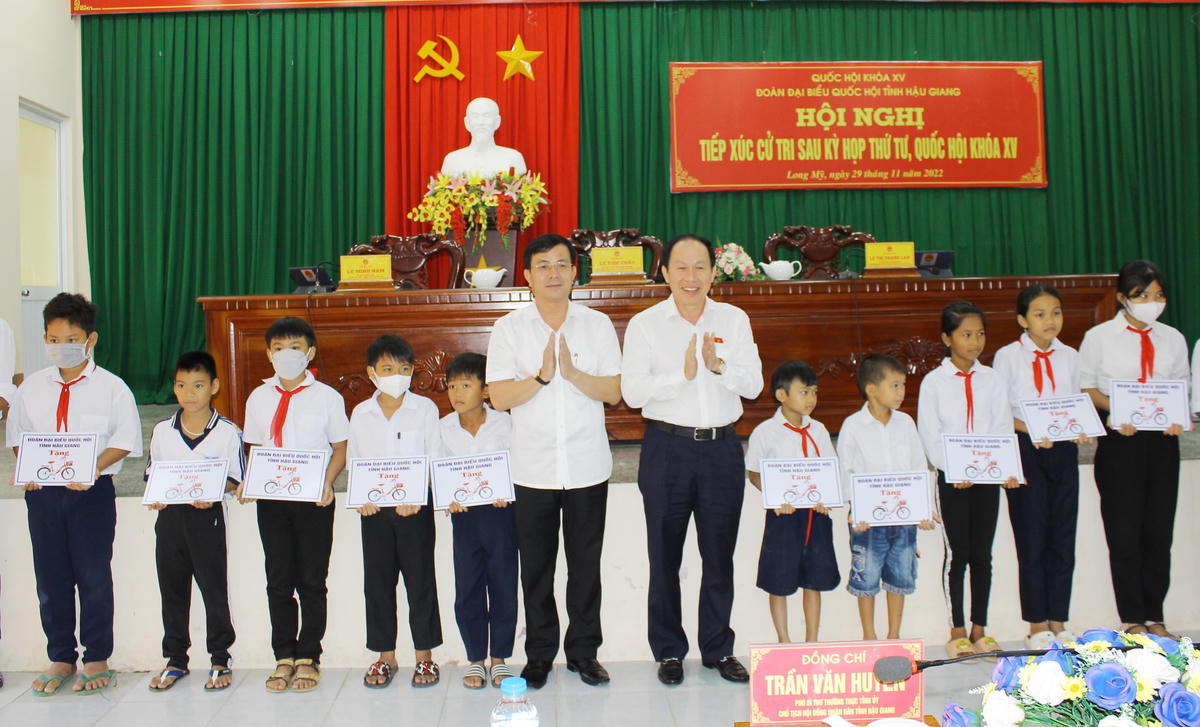 Phó Chủ tịch - Tổng Thư ký UBTƯ MTTQ Việt Nam Lê Tiến Châu cùng ông Trần Văn Huyến, Phó Bí thư tỉnh ủy Hậu Giang tặng xe đạp cho các em học sinh.