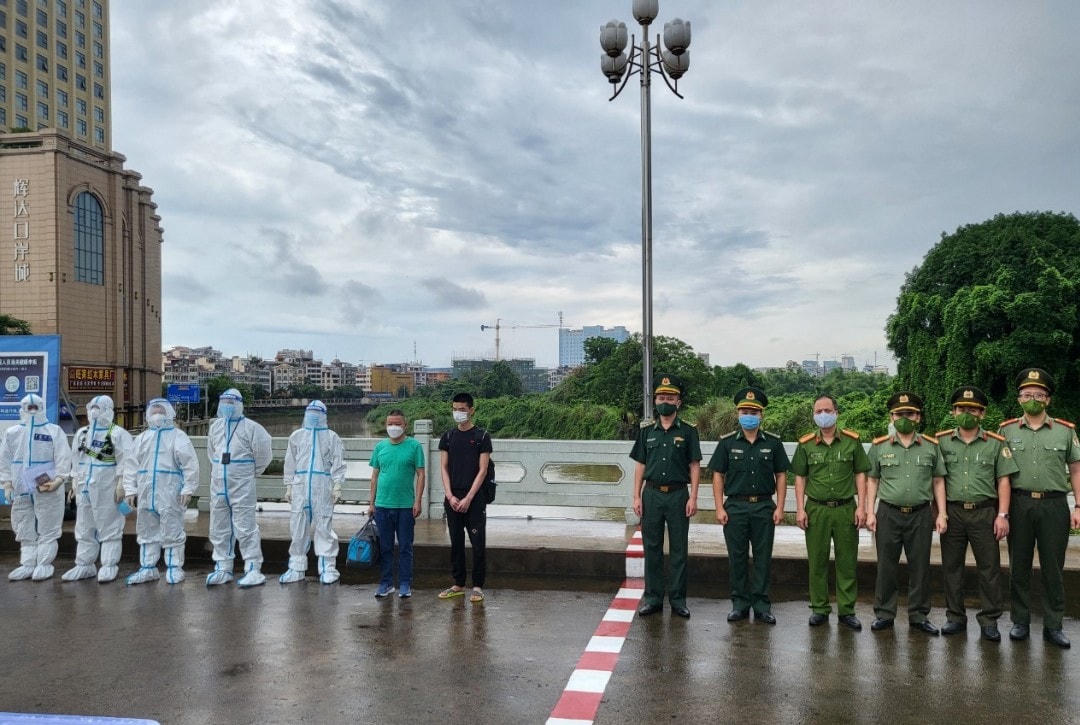 Lực lượng chức năng Việt Nam bàn giao 2 đối tượng truy nã cho Công an Trung Quốc. Ảnh: Công an Quảng Ninh.
