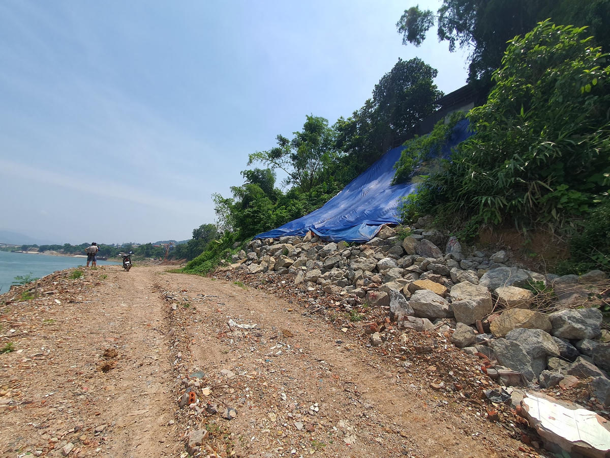 Do sợ bị sụt lún trước mùa mưa lũ, người dân phải dùng những tấm bạt để che tạm vào phần đất phía sau nhà đề phòng sạt lở.