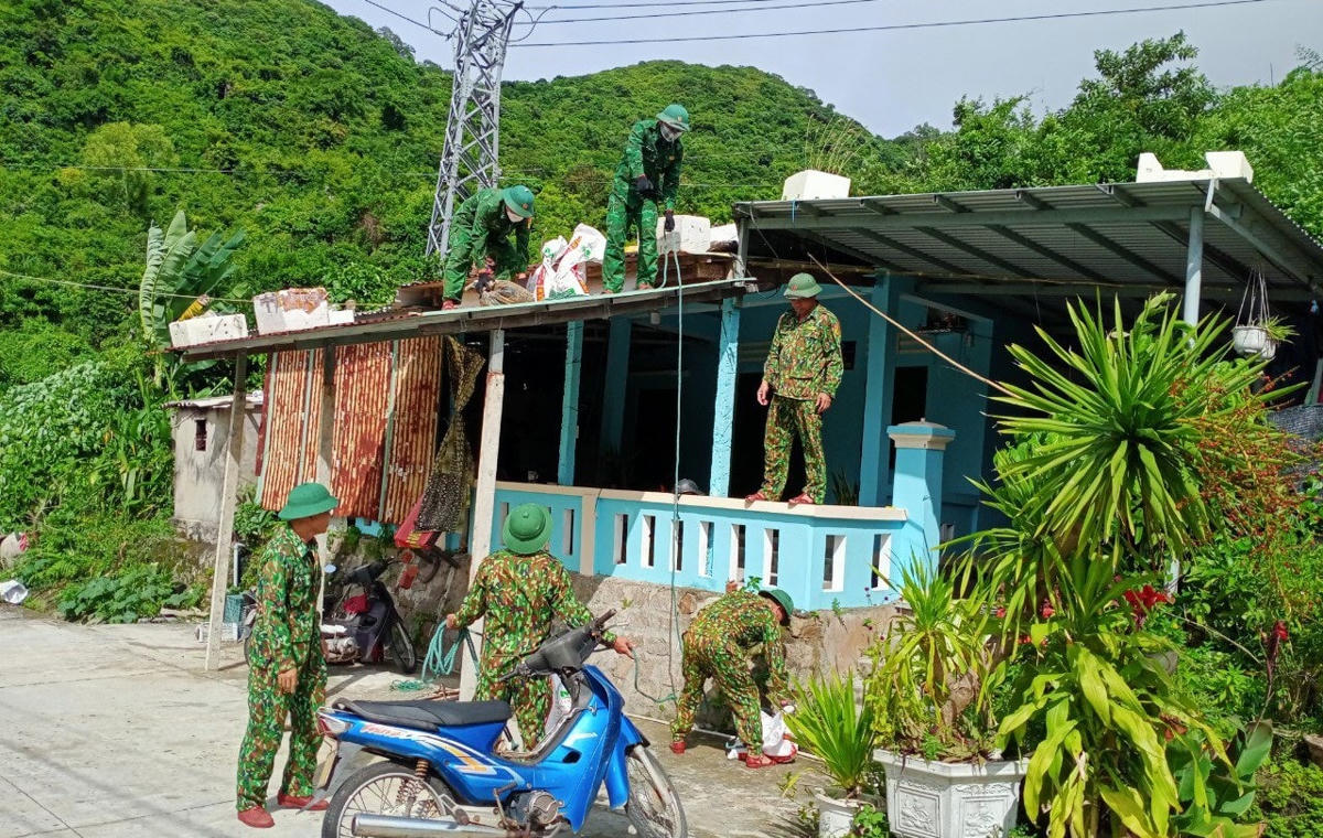 Lực lượng chức năng giúp người dân chằng chống nhà cửa ở xã đảo Tân Hiệp.
