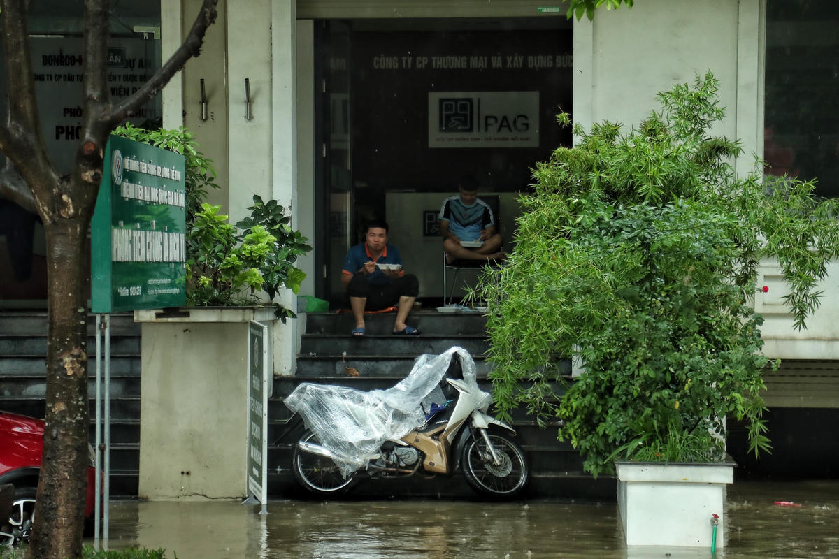 Thậm chí, do vũng nước sâu rất khó khăn để di chuyển, một số người phải ngồi ăn cơm ngoài hiên khu nhà liền kề.