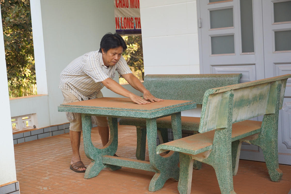 Bộ bàn ghế đá đầy bụi đỏ của nhà ông Võ Văn Hà, ấp 6, xã Bình Sơn. 