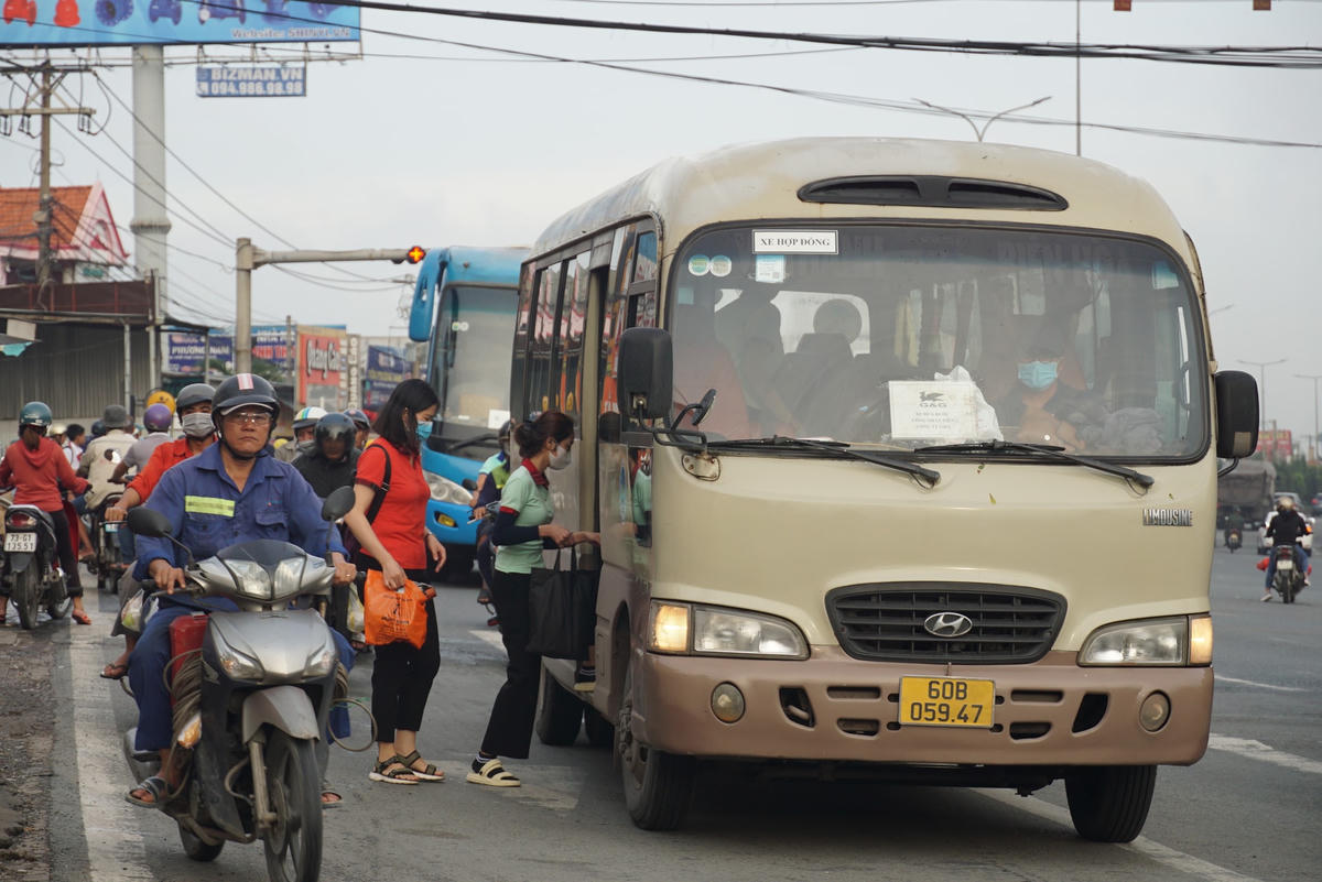 Giữa dòng người đông đúc, những chiếc xe đưa đón công nhân nối đuôi nhau đón khách ngay giao lộ Quốc lộ 51 – đường Ngô Quyền (phường An Hòa). Ảnh: Mạnh Thìn.