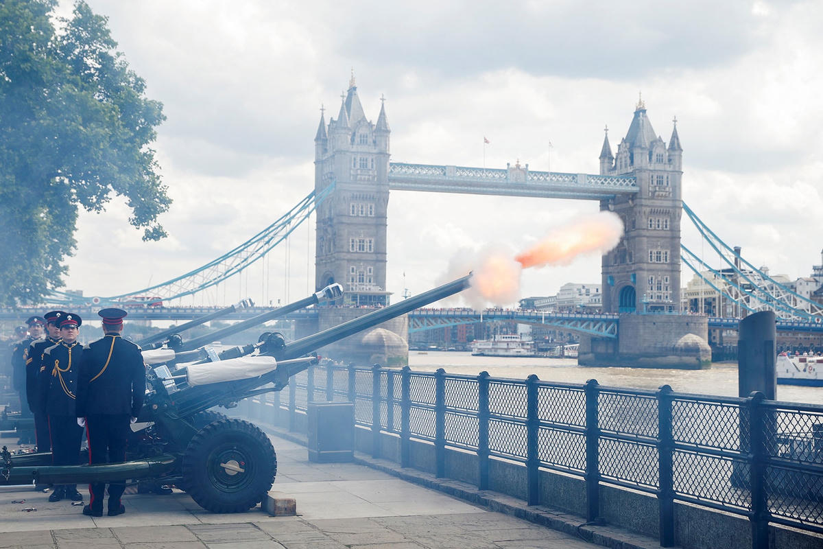 Đại bác khai hỏa bên bờ sông Thames, xa xa là cầu tháp London. Ảnh: Reuters.