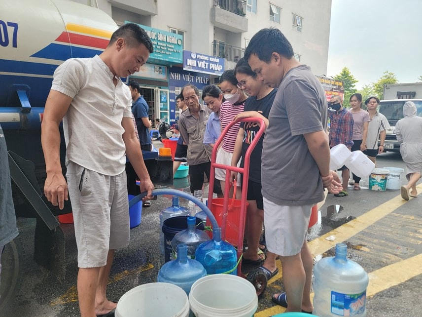 Người dân khu đô thị Thanh Hà (huyện Thanh Oai, Hà Nội) mang xô chậu lấy nước từ xe téc.  