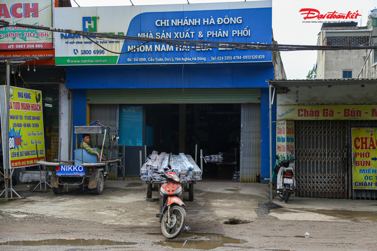 Cách bến xe Yên Nghĩa chừng 100 m một chiếc xe tự chế đang được bốc xếp hàng hóa dài với những thanh nhôm dài hàng chục mét tại một cửa hàng ở số 1059 Cầu Tuân, Do Lô, Yễn Nghĩa, Hà Đông đang chuẩn bị di chuyển.