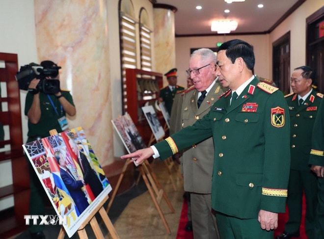 Bộ trưởng Bộ Quốc phòng Phan Văn Giang và Bộ trưởng Bộ các Lực lượng vũ trang Cách mạng Cuba Alvaro Lopez Miera tham quan trưng bày ảnh về quan hệ hợp tác giữa hai nước. (Ảnh: Trọng Đức/TTXVN) ttxvn-viet-nam-cuba-alvaro-lopez-miera-tham-chi-825342.jpg