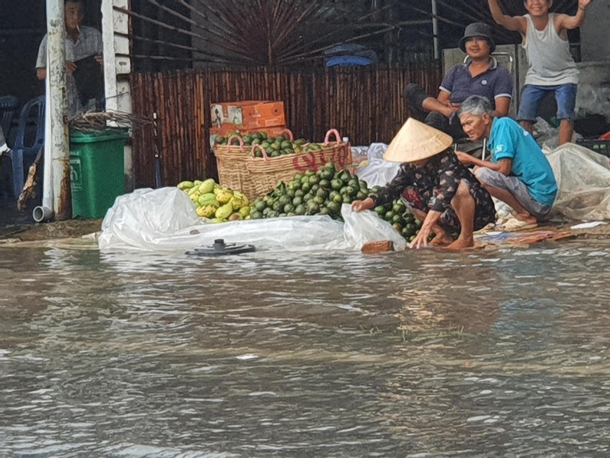 Tại đường Cao Văn Lầu nước ngập làm ảnh hưởng đến buôn bán của người dân.