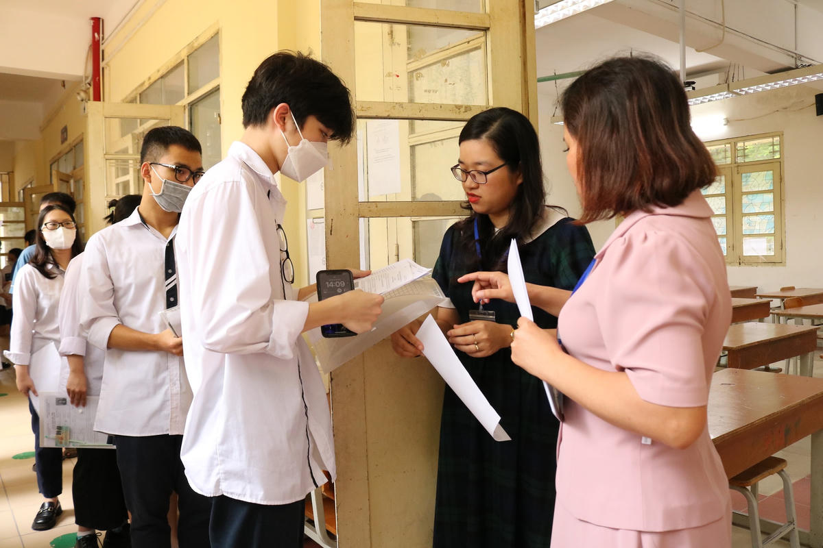 Cán bộ coi thi kiểm tra thông tin thí sinh trước khi vào phòng thi.