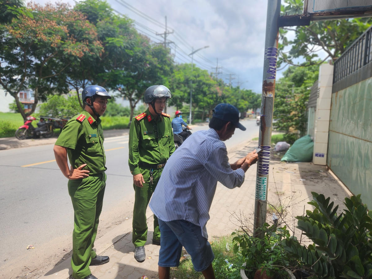 Lực lượng công an túc trực giám sát đối tượng khắc phục hậu quả quảng cáo "bẩn" đã gây ra.
