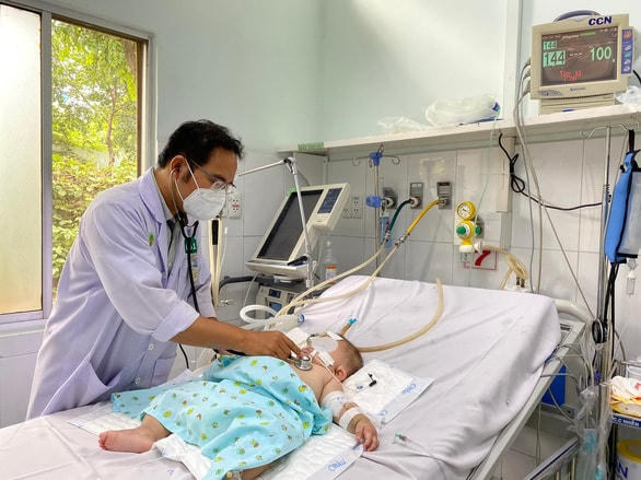 Bác sĩ Đỗ Châu Việt - Trưởng khoa hồi sức nhiễm Covid-19 Bệnh viện Nhi đồng 2 (TP Hồ Chí Minh), thăm khám một bệnh nhi mắc sốt xuất huyết nặng.  