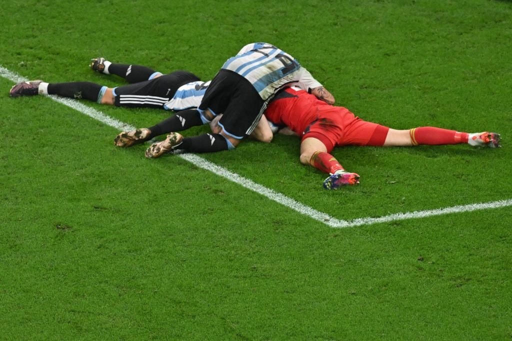 Đồng đội ôm Emiliano Martinez sau pha cứu thua quyết định ở phút bù giờ. Ảnh: Getty.