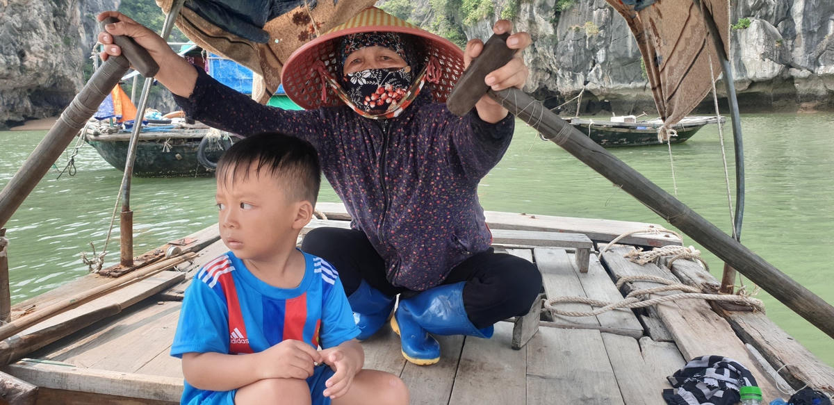 Bé Quyền cùng bà nội đi chèo đò ở bến cá Vincom.Ảnh: Nguyễn Quý.