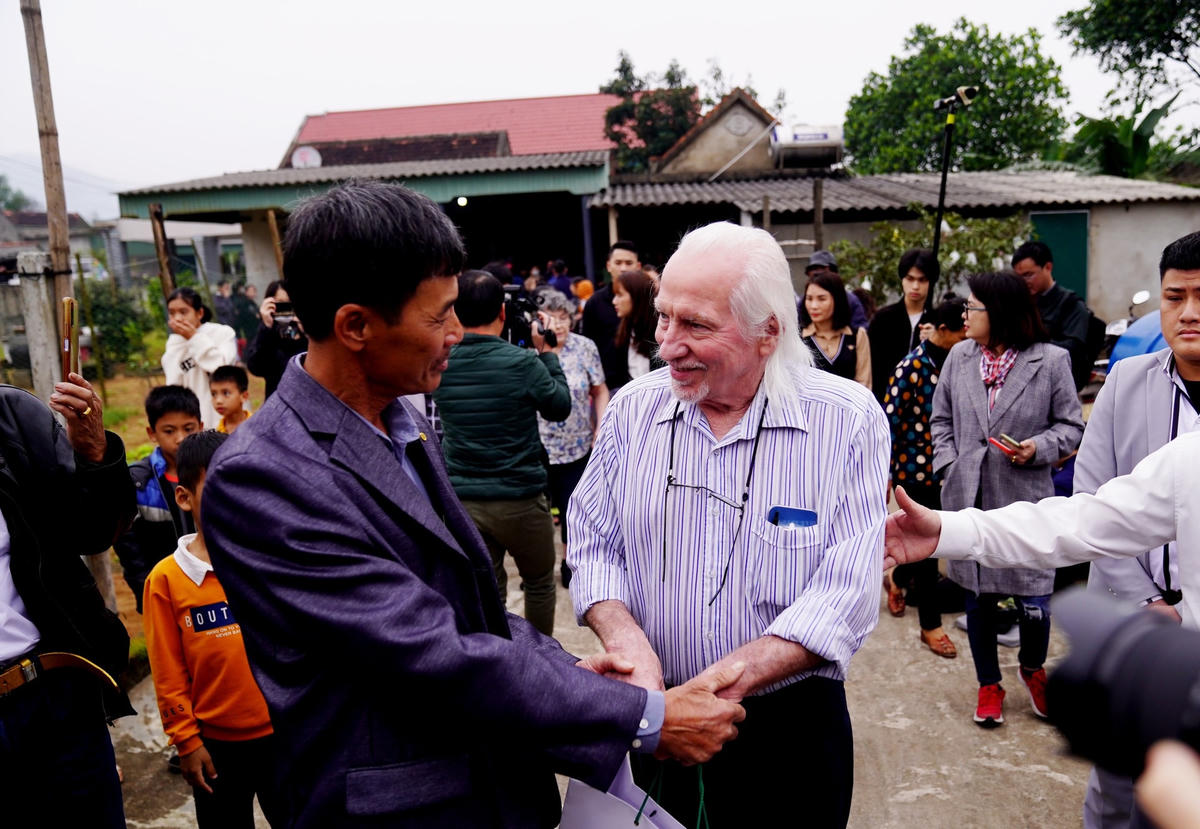 Ông Hà Huy Mỳ (cháu liệt sĩ Cao Xuân Tuất) nắm tay cựu binh Peter Mathews dẫn vào nhà.