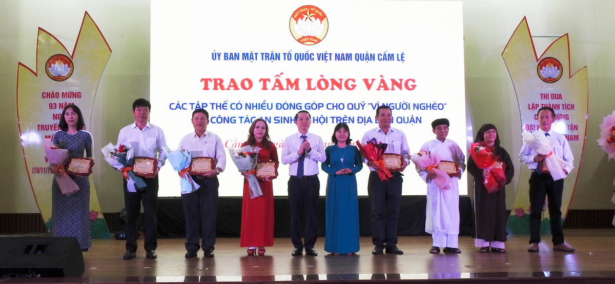 Bí thư Quận ủy Cẩm Lệ Nguyễn Văn Hùng và Trưởng Ban dân vận Quận ủy, Chủ tịch Ủy ban MTTQ Việt Nam quận Cẩm Lệ Phạm Thị Nhàn trao bảng ghi nhận Tấm lòng vàng cho các tập thể có nhiều đóng góp vào Quỹ Vì người nghèo. Ảnh: Thanh Tùng.