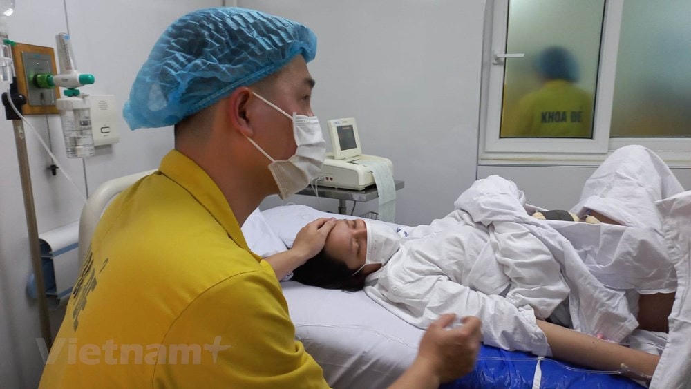 Người chồng vào phòng chờ sinh động viên các sản phụ. (Ảnh: T.G/Vietnam+).