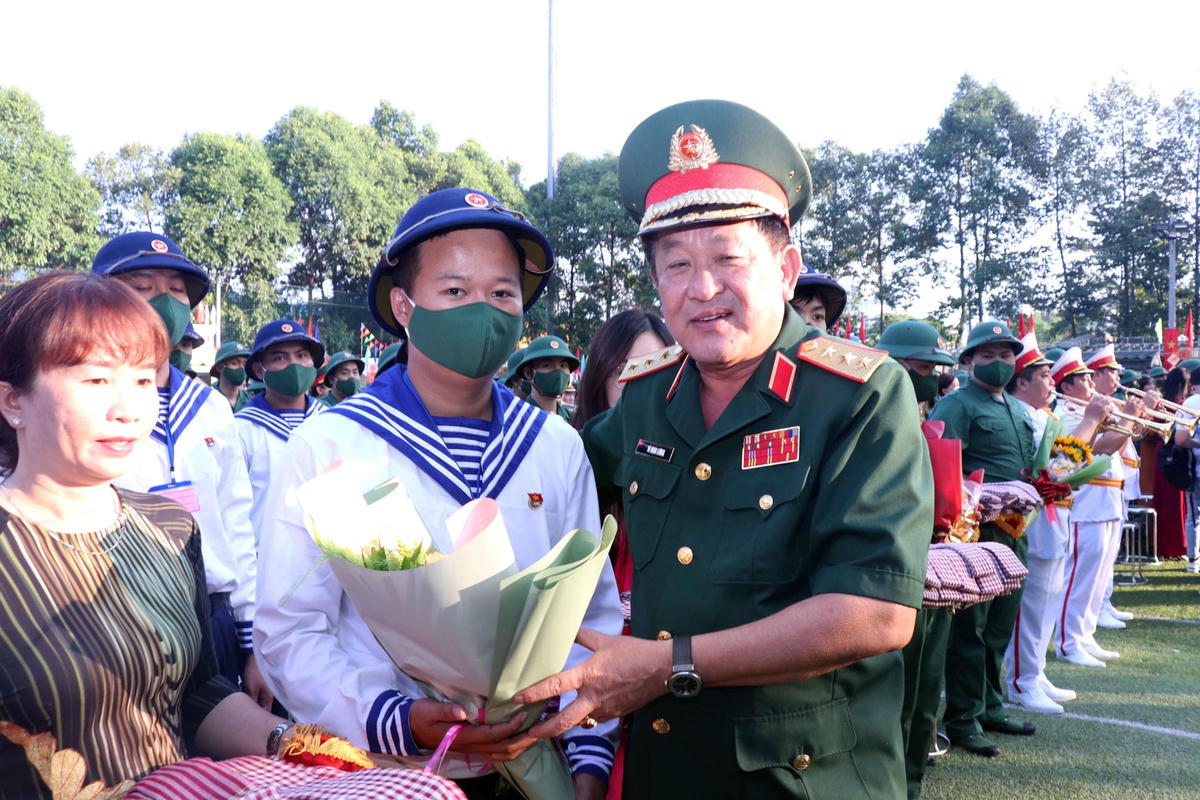 Thượng tướng Võ Minh Lương, Thứ trưởng Bộ Quốc phòng tặng hoa động viên thanh niên nhập ngũ tại điểm giao nhận quân TP Thủ Đức, TP HCM. (Ảnh: X.Khu).