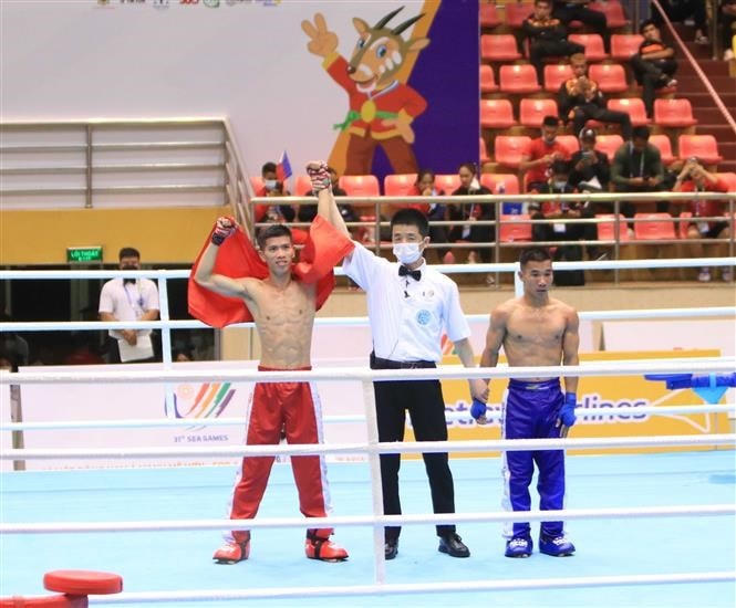 VĐV Huỳnh Văn Tuấn của đội kickboxing Việt Nam (đỏ) chiến thắng với tỷ số 3:0 trước Khamsathone Khamphouvanh của đội kickboxing Lào (xanh).( Ảnh: TTXVN).