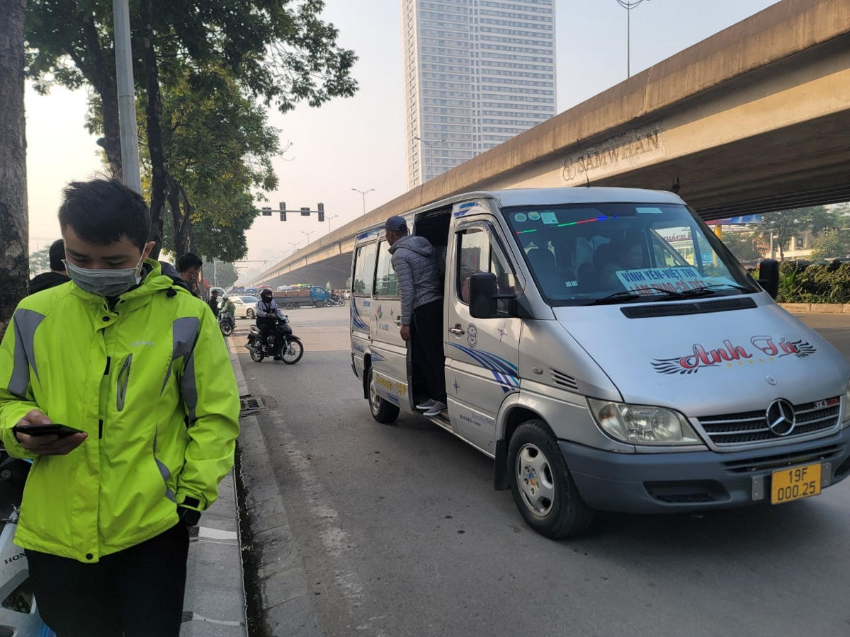 Xe "bò" từng chút một, phụ xe mở cửa, nhoài người ra ngoài vẫy khách.