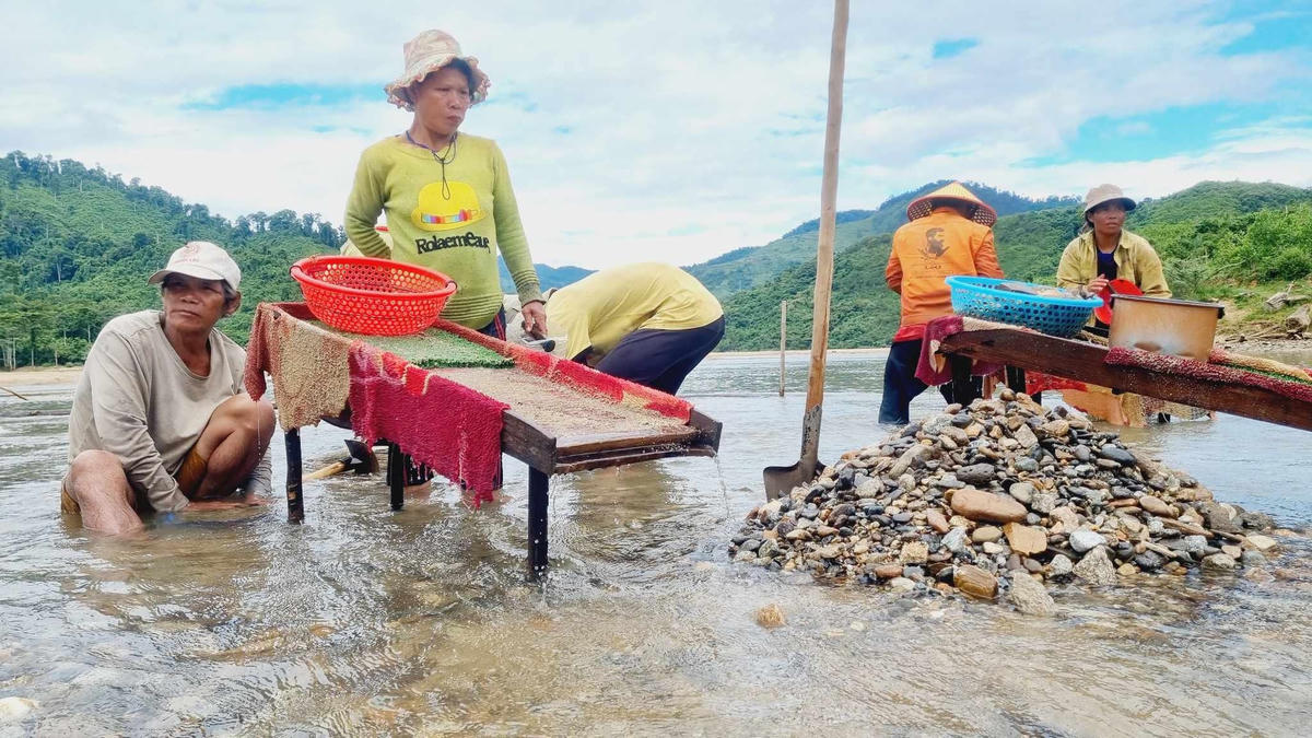 Người dân dùng dụng cụ thô sơ để đãi cát, sỏi đá tìm vàng.