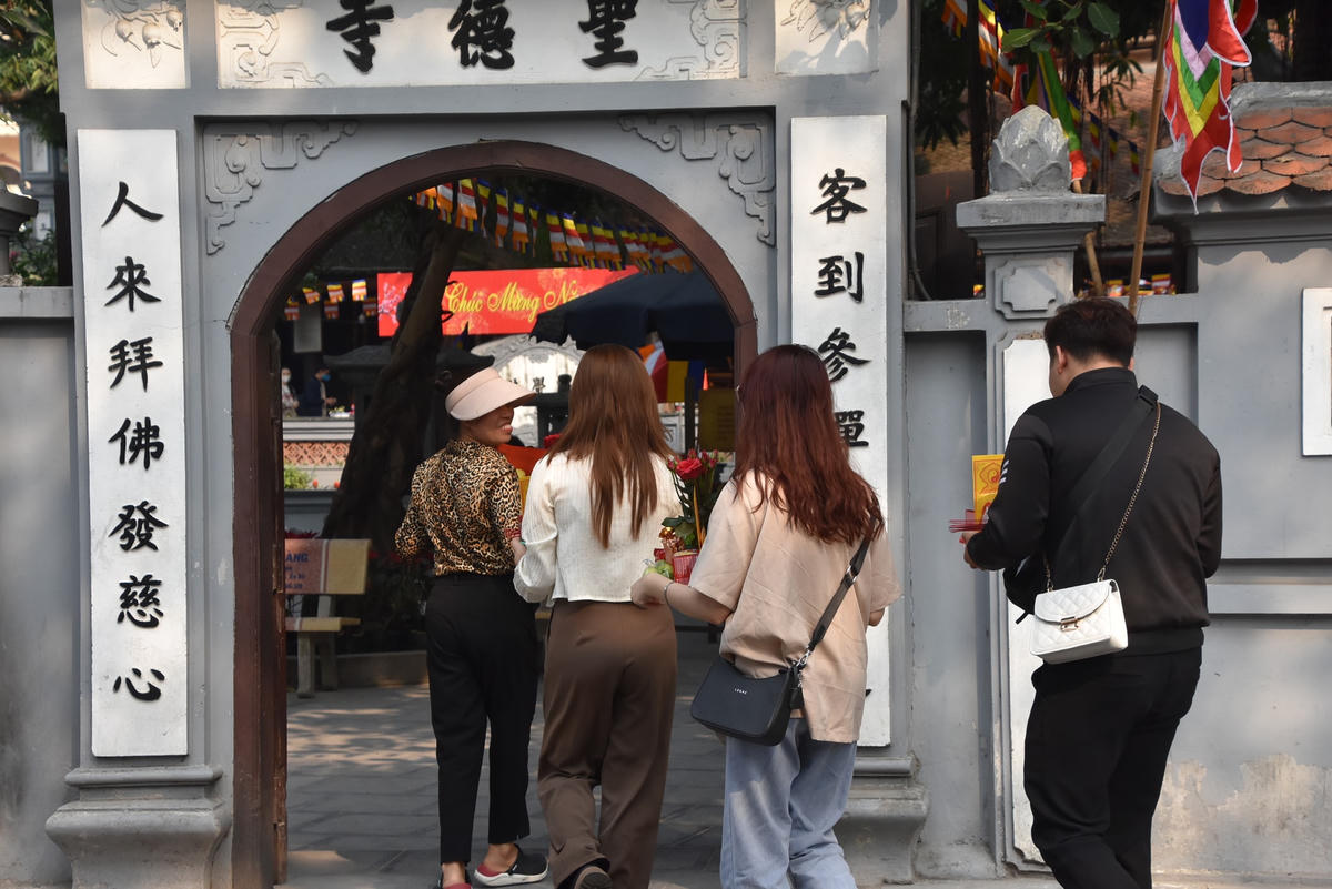 Từ ngoài cổng chùa, từng nhóm các bạn trẻ lần lượt vào làm lễ, dâng hương.