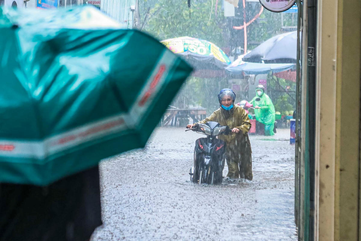 Nhiều phương tiện bị chết máy, người dân khổ sở dắt xe qua vùng ngập.