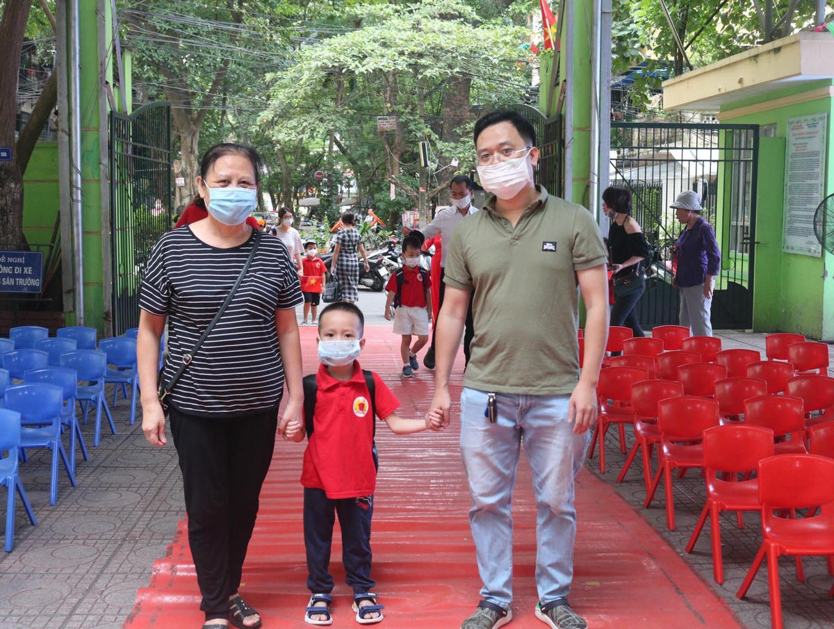 Từ 6h30, nhiều phụ huynh đã đưa con đến trường dự lễ khai giảng. Khu vực gần trường, cha mẹ tranh thủ mua cờ, băng rôn rộn ràng đưa con tản ra các lớp học.