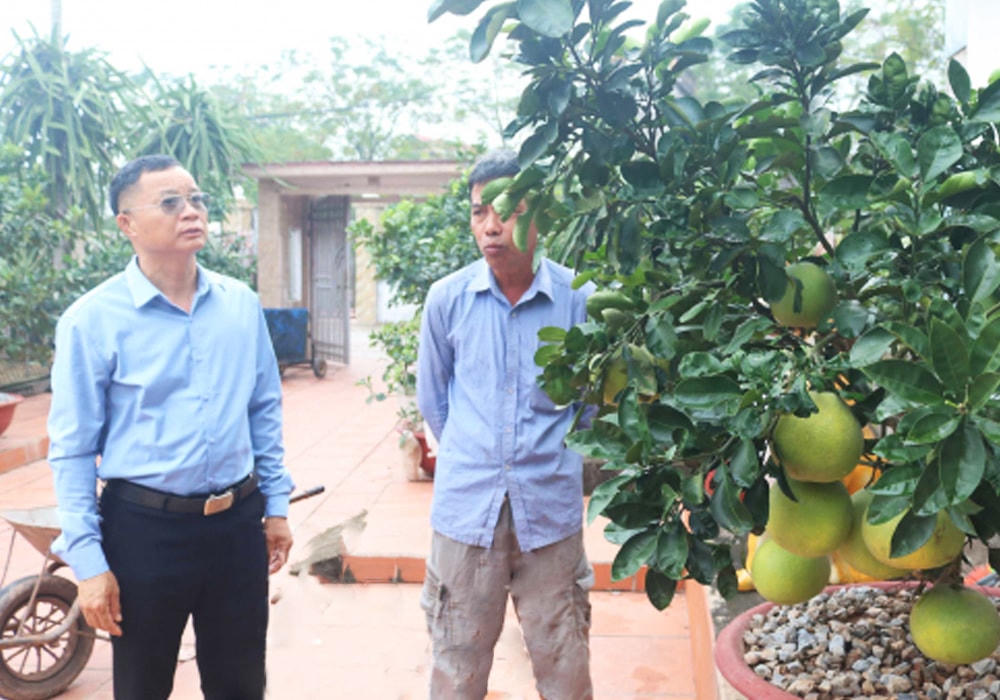 Ông Nguyễn Quang Khánh (bên trái) vận động nhân dân phát triển kinh tế gia đình. Ảnh: Tiến Đạt.