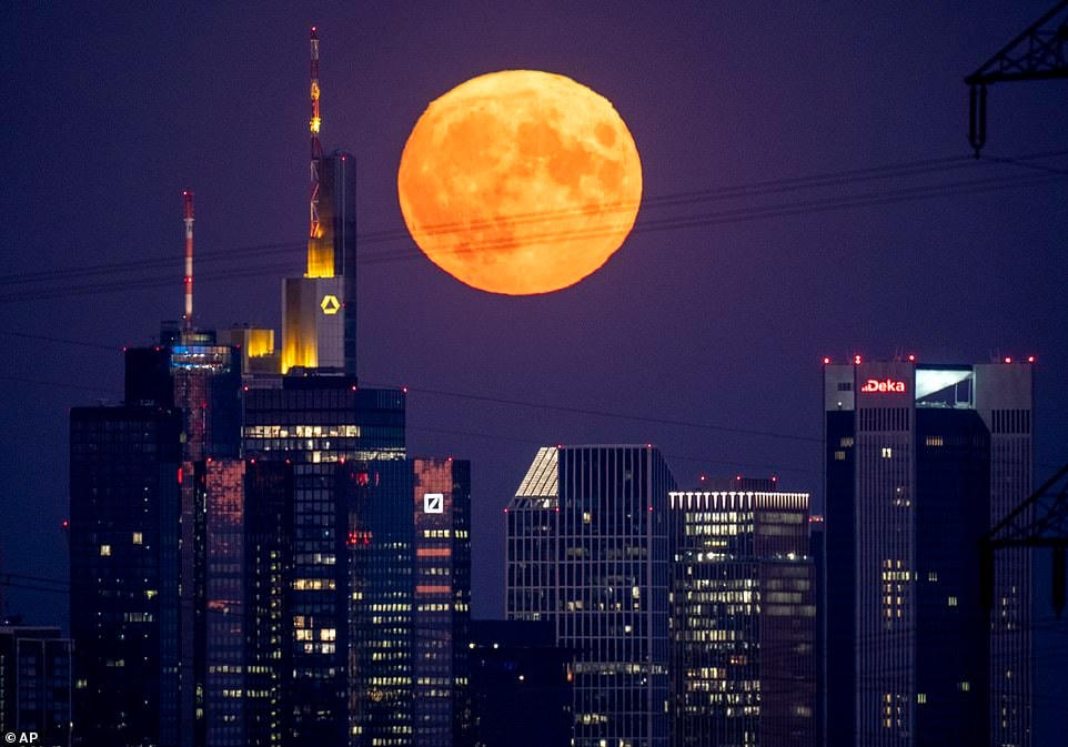 Mặt trăng như thể đang treo lơ lửng bên trên các tòa nhà chọc trời ở Frankfurt, Đức. Ảnh: AP.