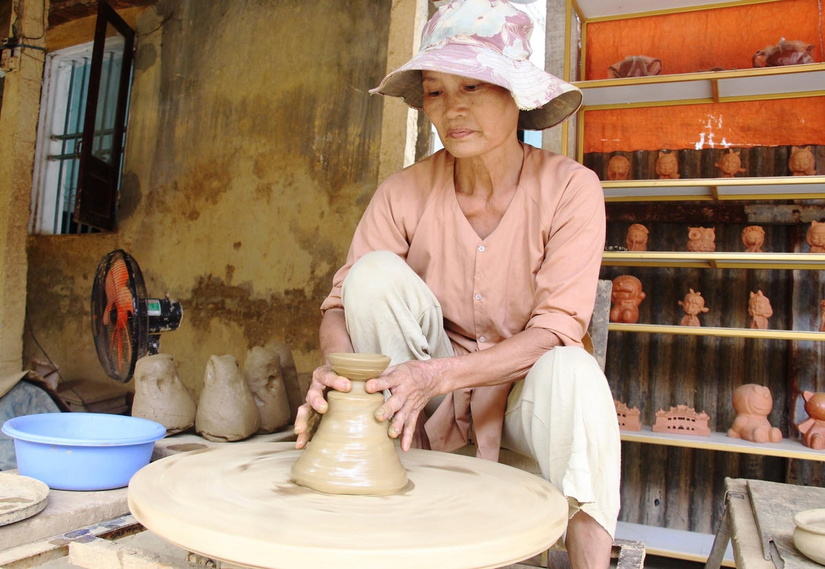 Bà Nguyễn Thị Thủy đang làm nắp nồi đất.