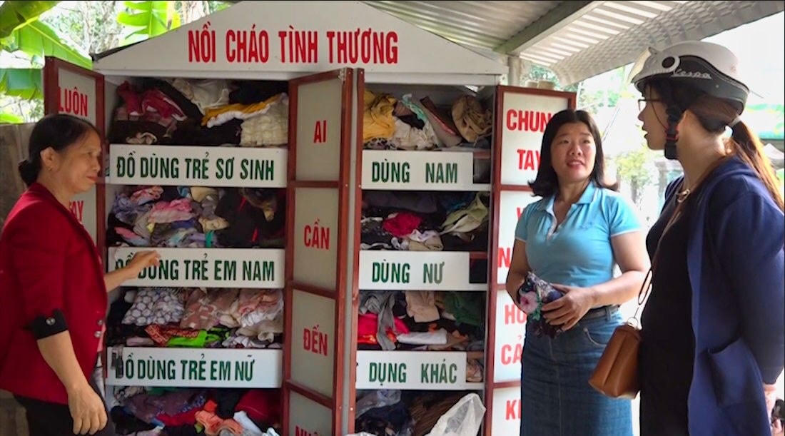 Chị Nguyễn Thị Hồng Phúc (ở giữa) tại “Tủ áo quần tình thương” nhằm chia sẻ khó khăn với những người kém may mắn.