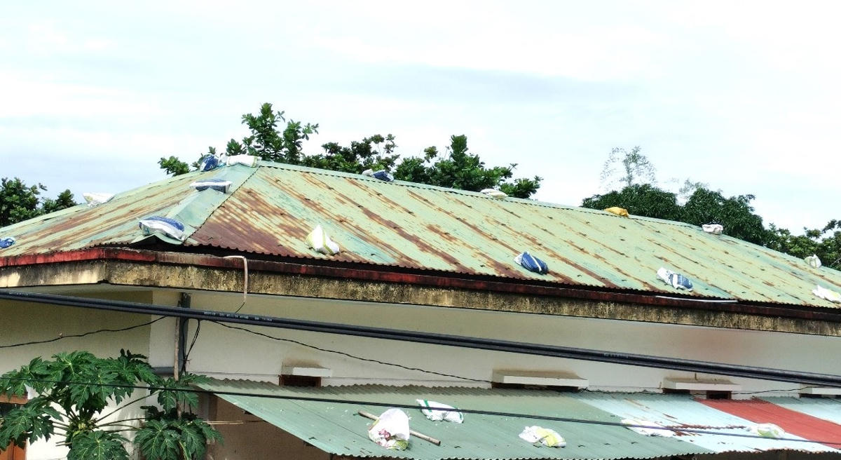 Một nhà dân ở phường Cửa Đại gia cố mái tôn bằng bao cát.