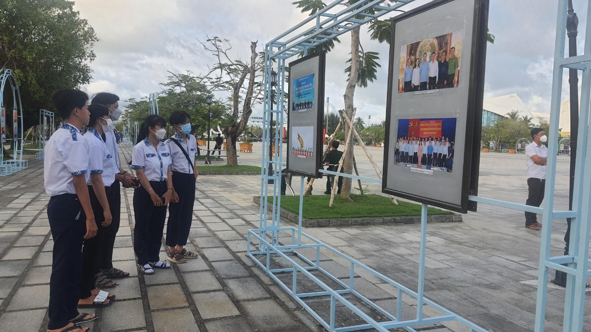 Các em học sinh tham quan triển lãm ảnh.