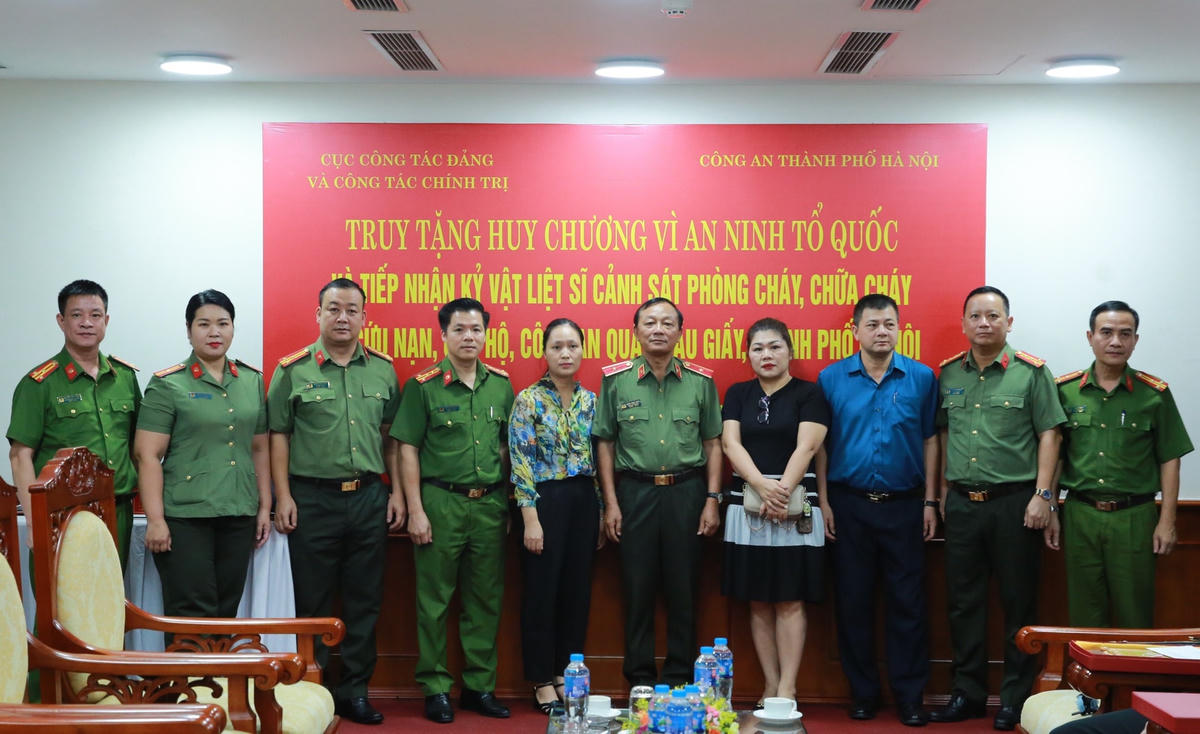 Lãnh đạo Bộ Công an, Công an TP Hà Nội cùng thân nhân 3 liệt sĩ tại buổi lễ.