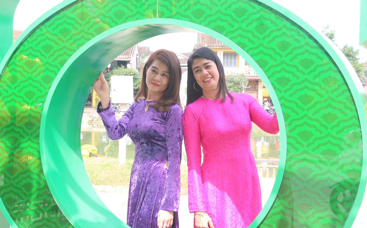 Nhiều người tạo dáng chụp ảnh lưu niệm khi đi du xuân phố cổ Hội An.