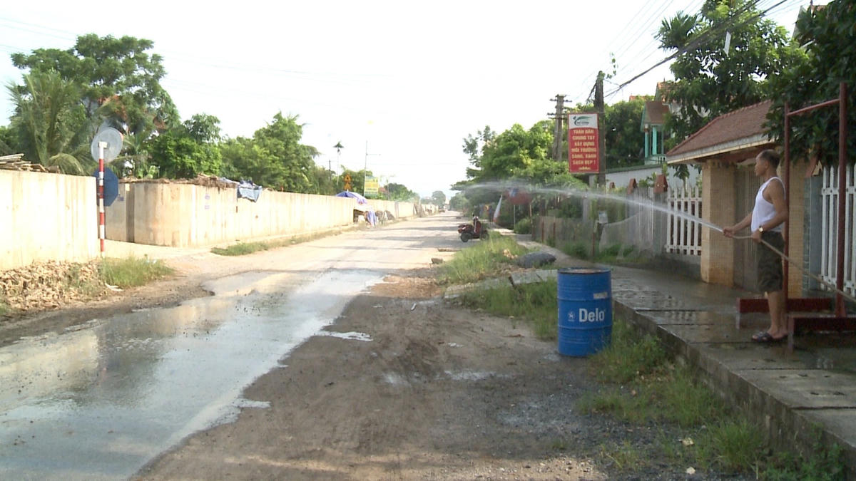 Người dân ở tỉnh lộ 315 thường phải tưới nước để đỡ bụi