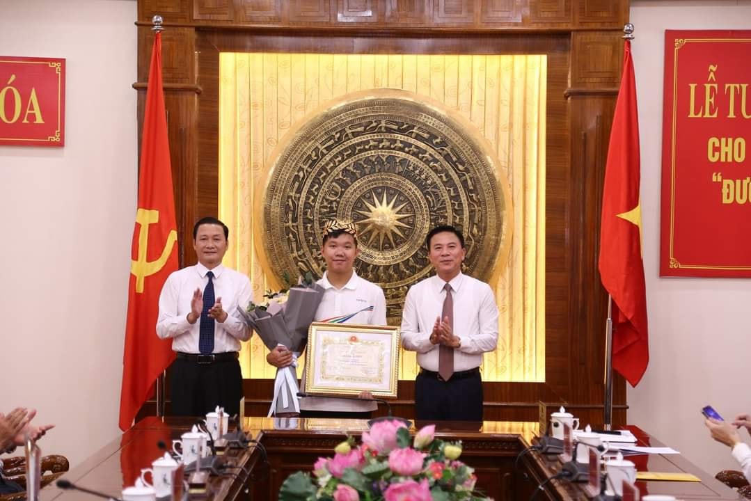 Ông Đỗ Trọng Hưng, Bí thư Tỉnh ủy (bên phải) và ông Đỗ Minh Tuấn, Chủ tịch UBND tỉnh (bên trái) trao bằng khen và hoa cho quán quân Olympia Lê Xuân Mạnh.
