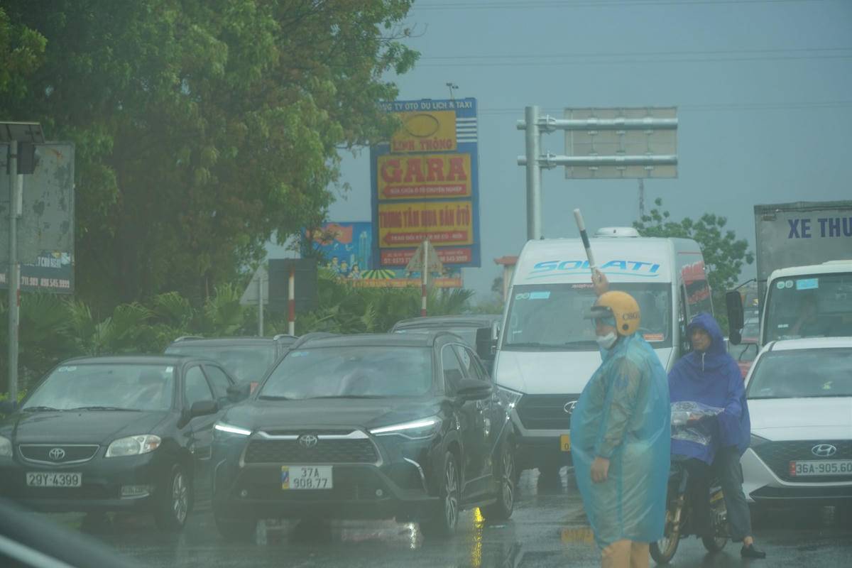 Từ khoảng 9 - 12h, khu vực Thanh Hóa mưa to, các lực lượng điều tiết giao thông phải dầm mưa suốt 3h đồng hồ để phân luồng, hướng dẫn cho người dân.    