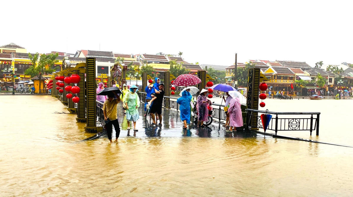 Nhiều du khách check trên cầu An Hội đang bị ngập nước.