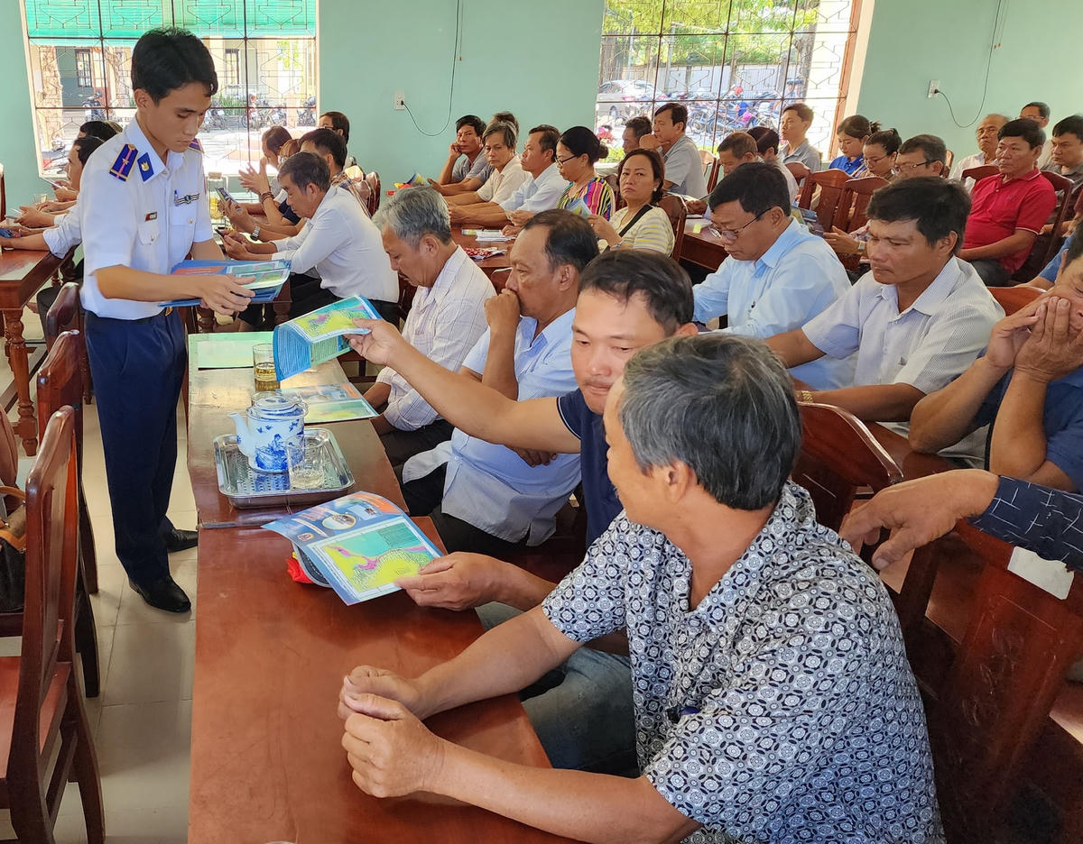 Phát tờ rơi tuyên truyền về khai thác hải sản trái phép, không báo cáo và không theo quy định.