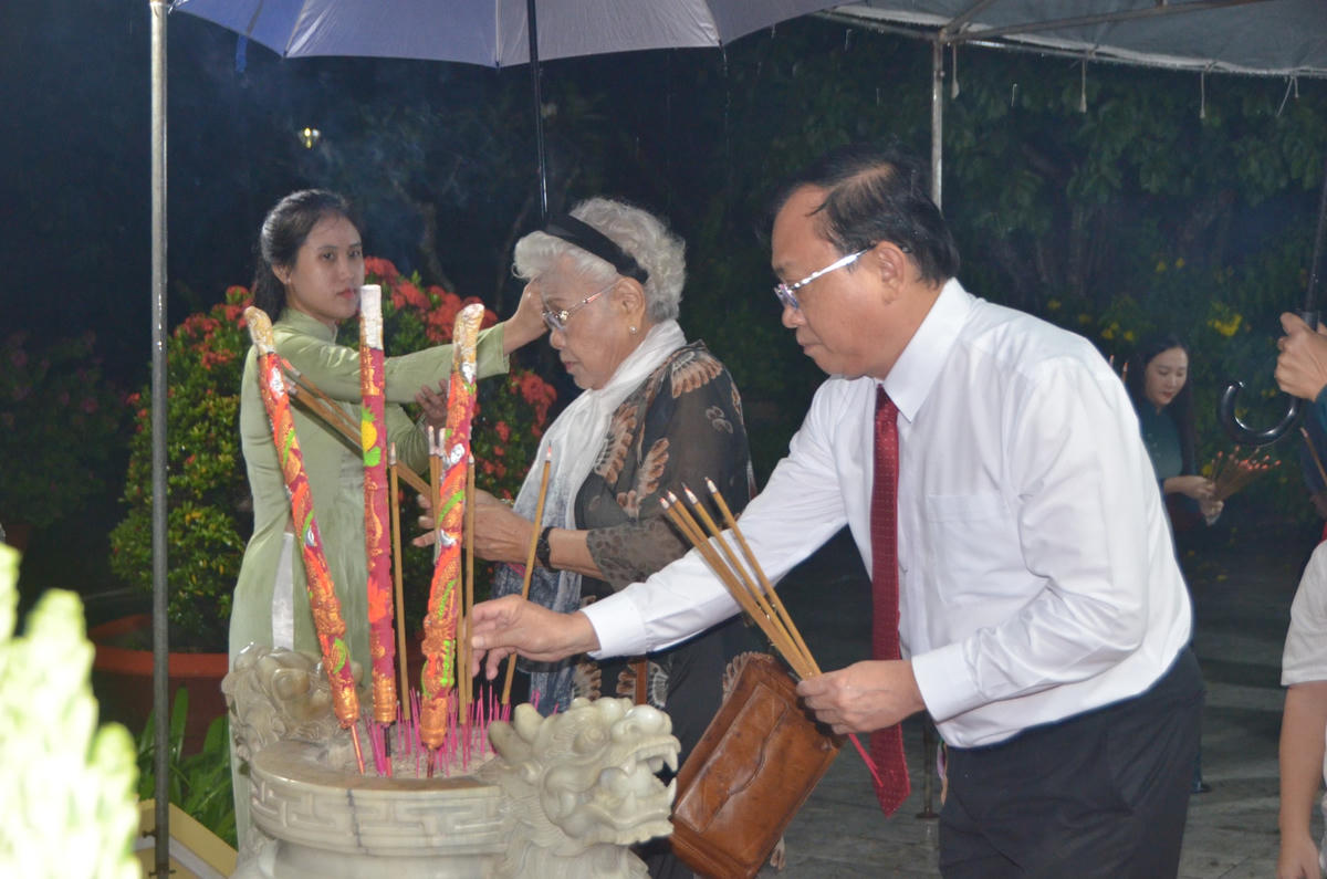 Phó chủ tịch thường trực UBND tỉnh Bạc Liêu Lê Tấn Cận ( áo trắng) thắp nén hương lên phần mộ của cố nhạc sĩ Cao Văn Lầu.