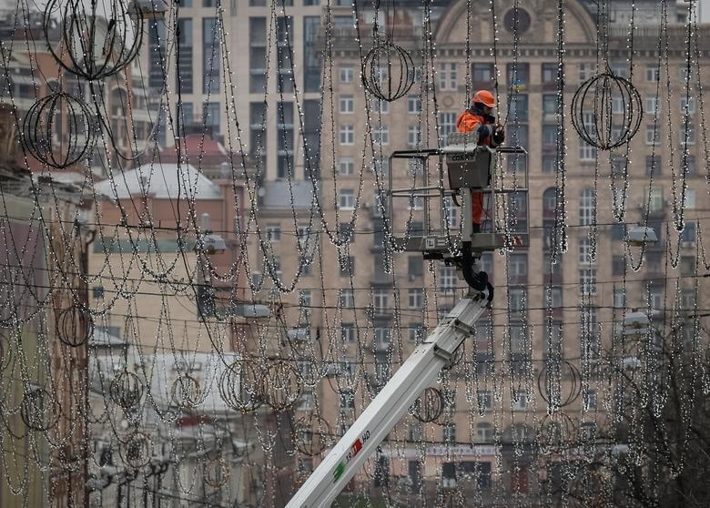 Công nhân lắp đèn trang trí cho lễ Giáng sinh và Năm mới ở trung tâm Kyiv, Ukraine.