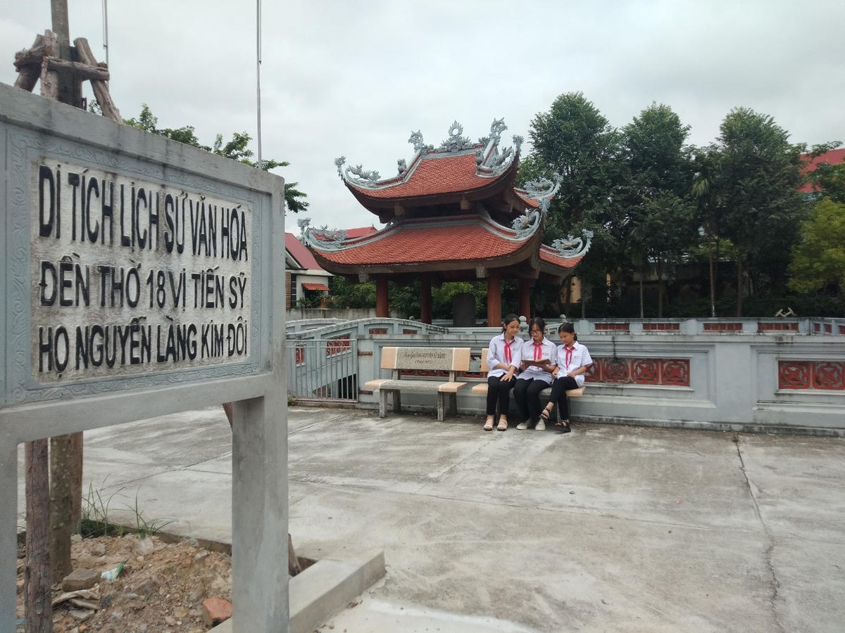 3 cô học sinh đang trao đổi bài tại khuôn viên của di tích như tiếp nối truyền thống hiếu học của một thời bảng vàng năm xưa.