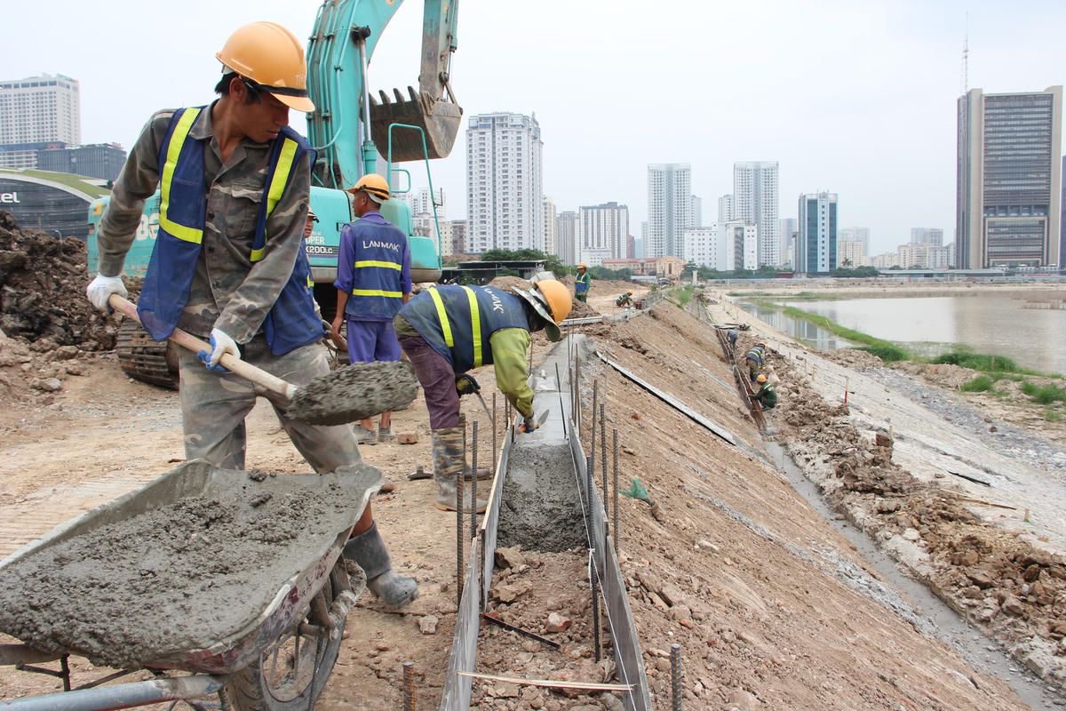 Công nhân tiến hành xây dựng đường nước, đổ thành kè.